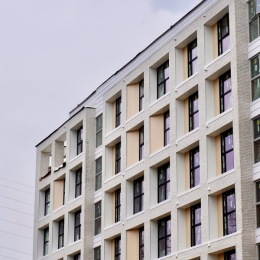 the corner of a high rise building with several windows